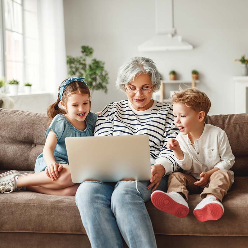 Grandmother with grandchildren using laptop