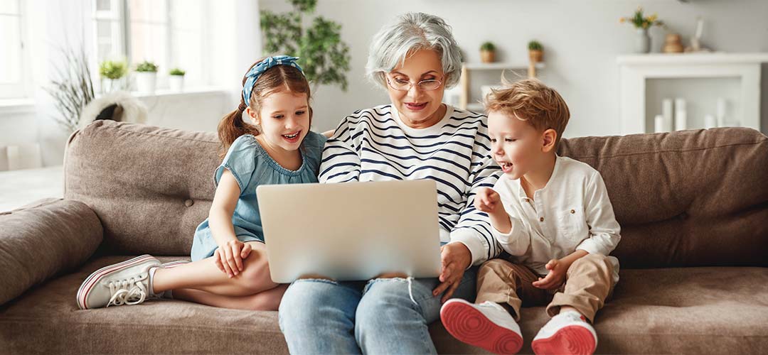 Grandmother with grandchildren using laptop