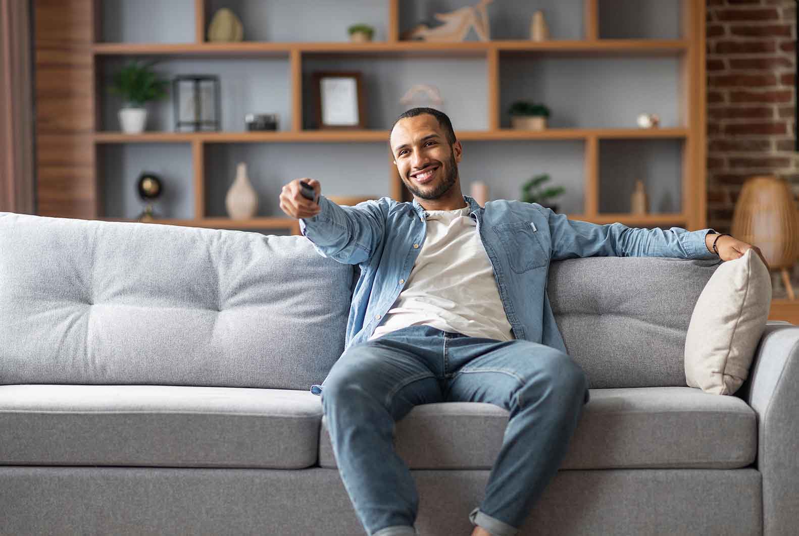 Man pointing remote at TV